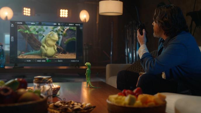 The GEICO Gecko on set with a director and he looks into a monitor to see Leo the Lizard on the screen