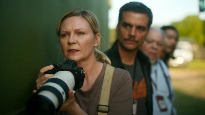 Kirsten Dunst as a war photographer, holding a large lens