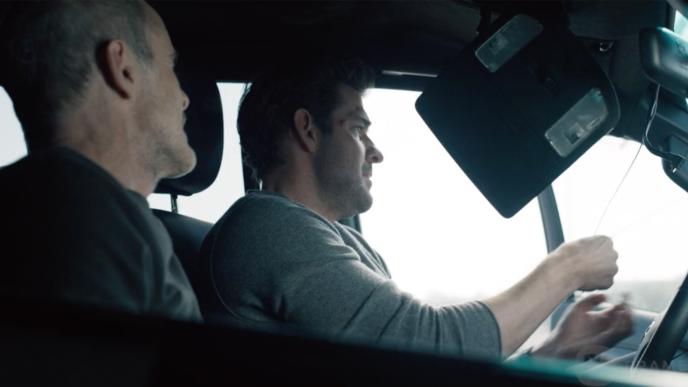 Jack Ryan in a car with a box dangling from the car ceiling