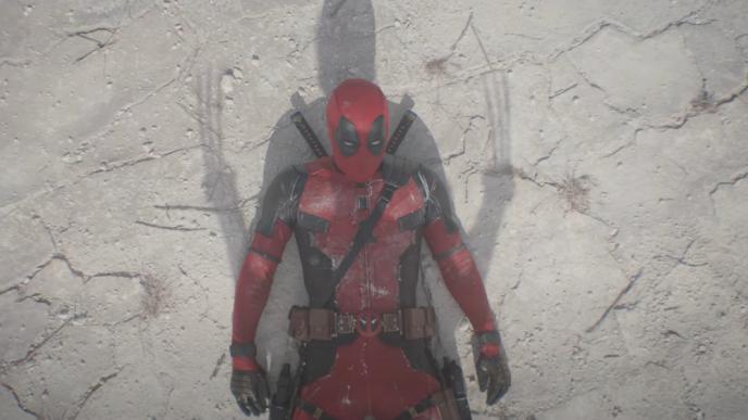 Deadpool is on the ground, the shadow of Wolverine over him