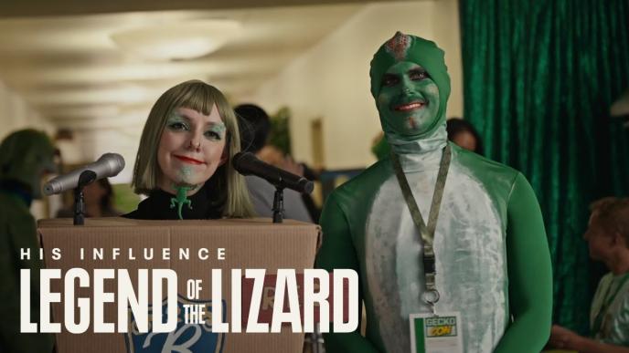A man and a woman dressed in GEICO Gecko garb. The words "His Influence. Legend of the Lizard" are on the photo