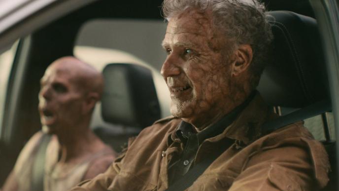 Will Ferrell as a zombie driving a car, with another zombie in the passenger seat