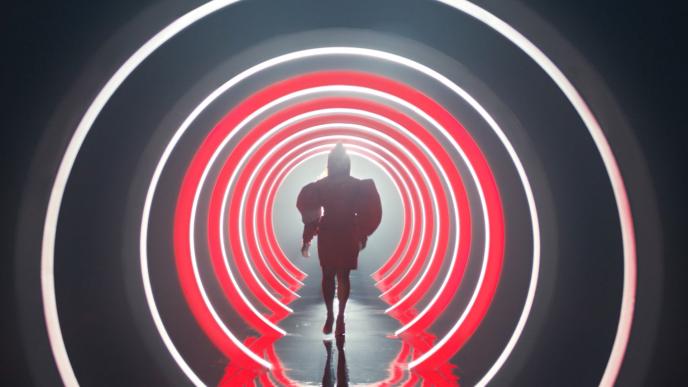 The silhouette of actress Quinta Brunson as she down a futuristic catwalk surrounded by red and white rings