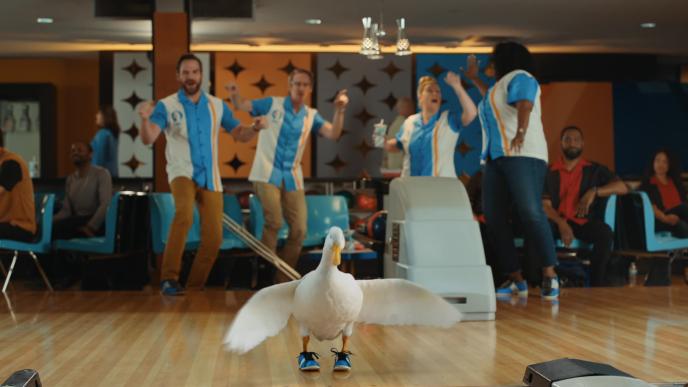 A still from a commercial showing a duck ten pin bowling