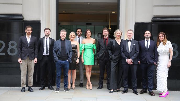A team of men and women dressed up taking a group photo outside