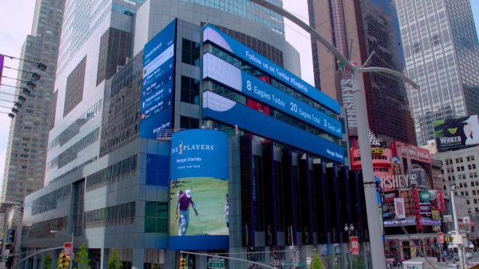 Large screens in Times Square displaying golf stats