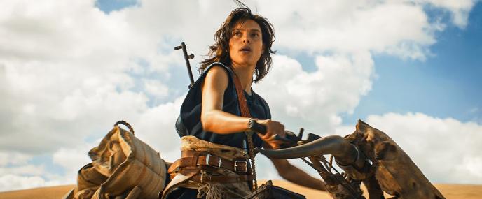 Mary Jabassa sits on a motorcycle on top of a sand dune