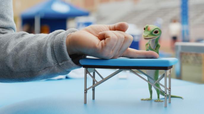 The CG animated GECIO Gecko massages a finger on a miniature massage table