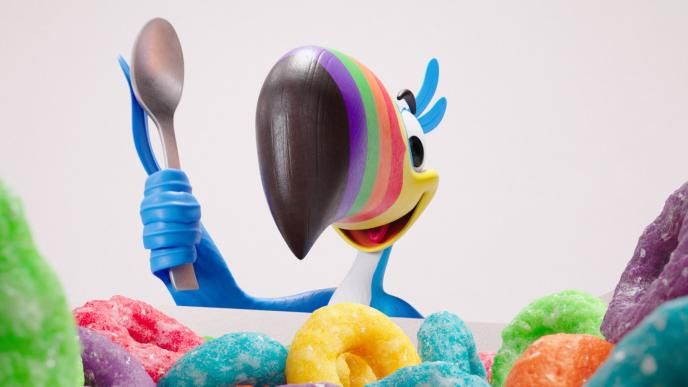 Animated Toucan Sam holds a spoon in the air as he begins to eat a bowl of Froot Loops cereal