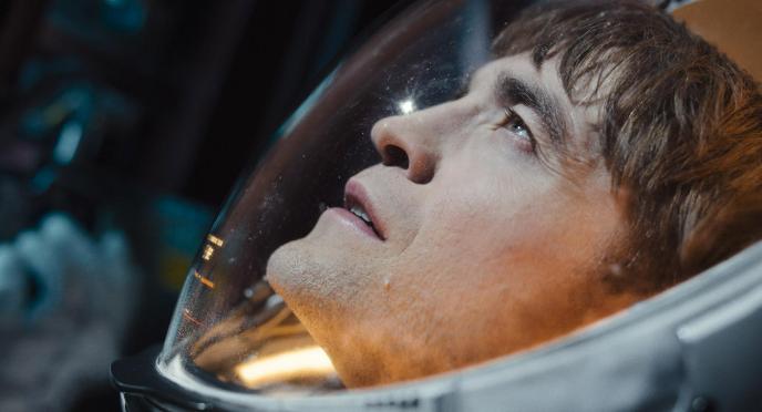 Robert Pattinson in Mickey17, wearing a spacesuit and looking out into space