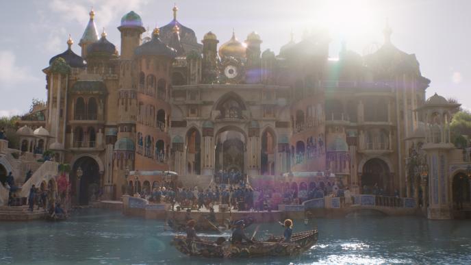 A finished shot from Wicked Part One. The Shiz University facade has been digitally extended upwards, lighting adjusted, and the lake water recoloured blue