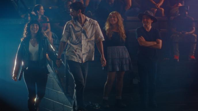A man and a woman hold hands walking into a concert venue