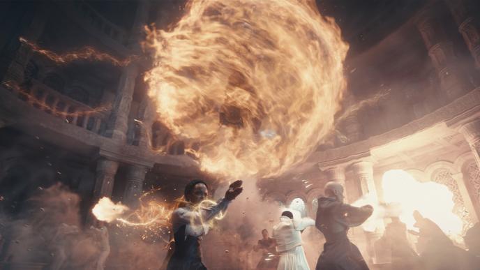 A scene from The Wheel of Time showing CGI strands of fire and yellow light swirling around the room to create a floating ball.