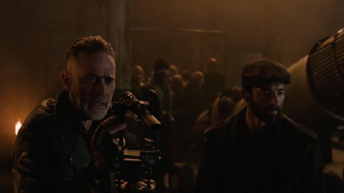 Negan from The Walking Dead: Dead City stands on a balcony with a gun aimed