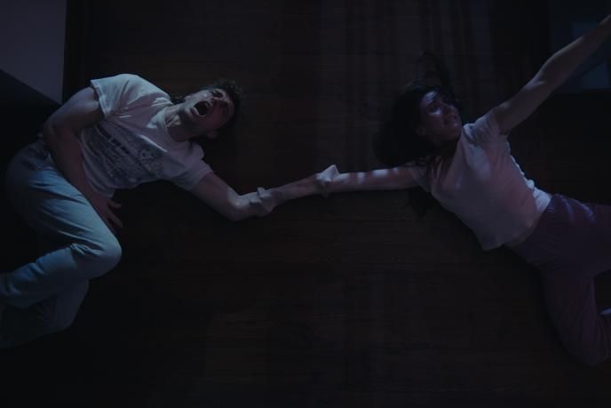 Top angle shot of the scene where Millie and Tim's hands fuse together 