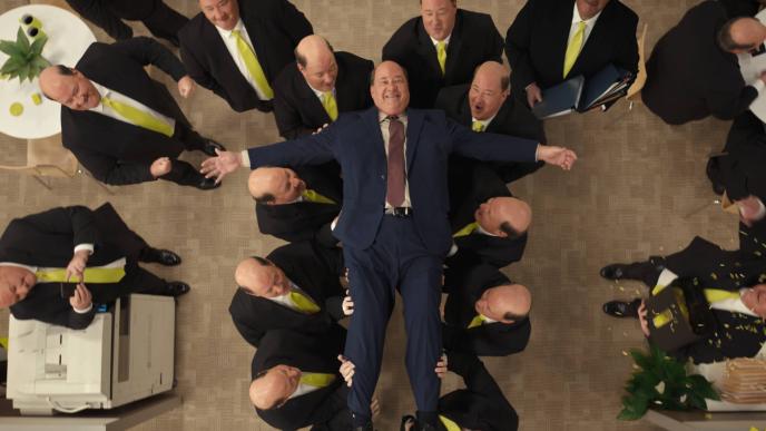Actor Brian Baumgartner in an office setting crowd surfing with his clones