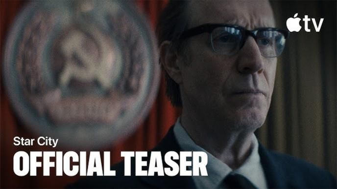 A man with glasses and a serious expression stands before blurred seal, Apple TV logo and “Star City Official Teaser” text visible.