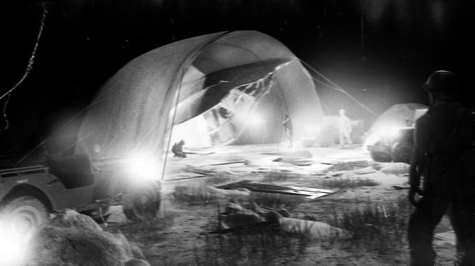 Concept art depicting old footage of a crashed UFO being analysed by the army