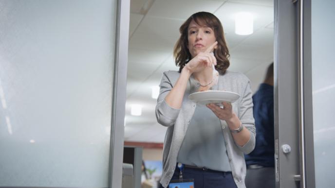 a person holding a plate walking through a room