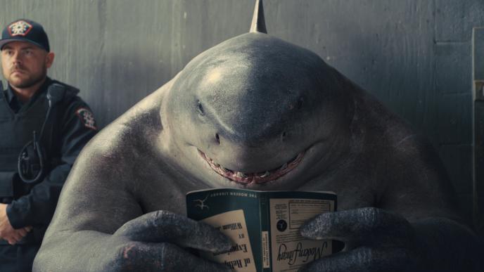 King Shark reading a book upside down