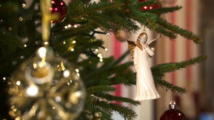 close up shot of an angel ornament hanging on a christmas tree