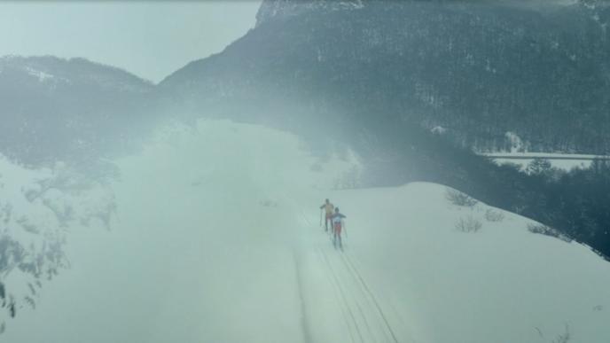 two people skiing down a misty mountain