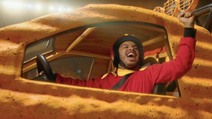 close up shot of a person grinning with victory in a yellow monster truck