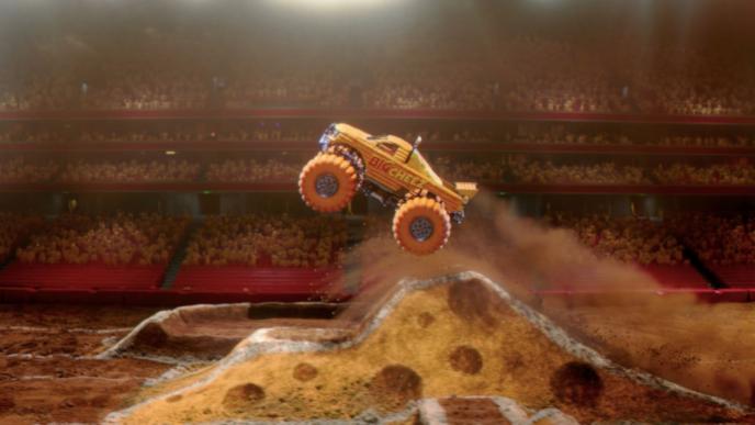 an animated yellow monster truck that has the text 'big cheez' on the side. it is mid air, going off a ramp 