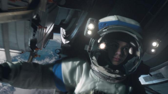 close up shot of an astronaut in space next to a satellite