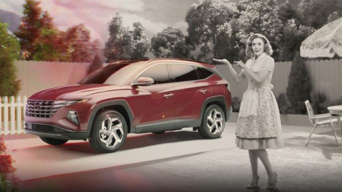 a black and white image of a 50s housewife in a garden standing next to a red hyundai 4x4 car