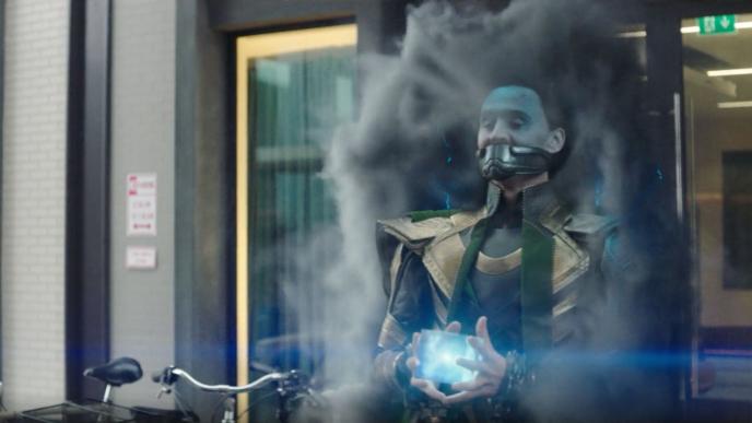 loki character coming out of a smoky portal in a mouth cuff holding a luminescent cube