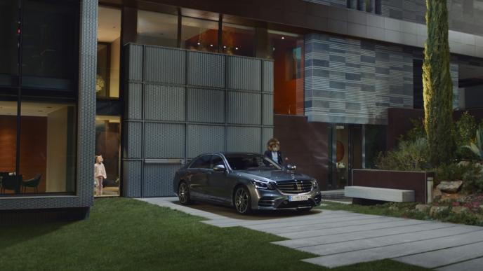businessperson with the head of a lion standing next to a mercedes benz s class outside of a modern house