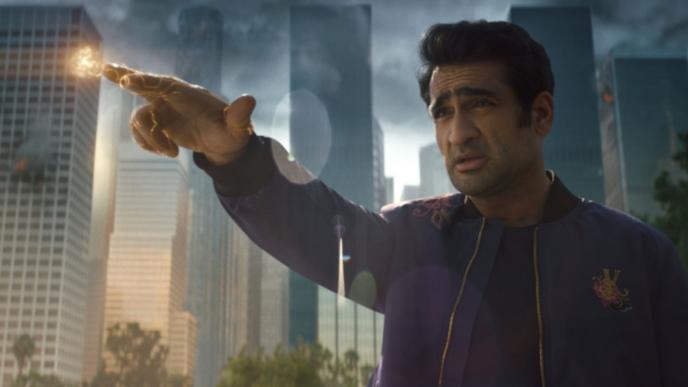 actor kumail nanjiani pointing his fingers that have been animated to look like they are illuminated while looking into the distance