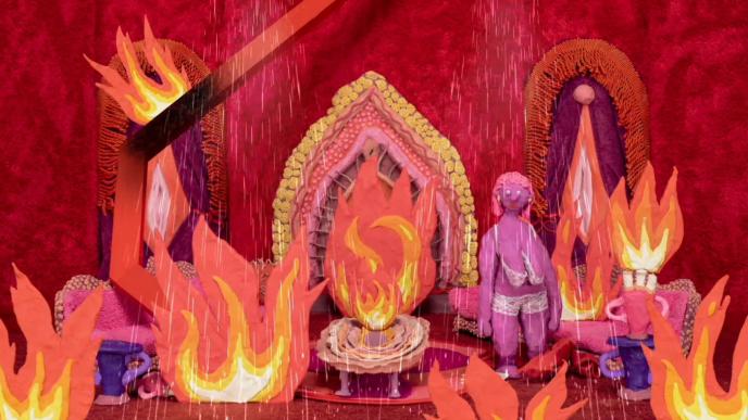a stopmotion character standing in a room that is on fire. there is sprinkler water coming out of the ceiling