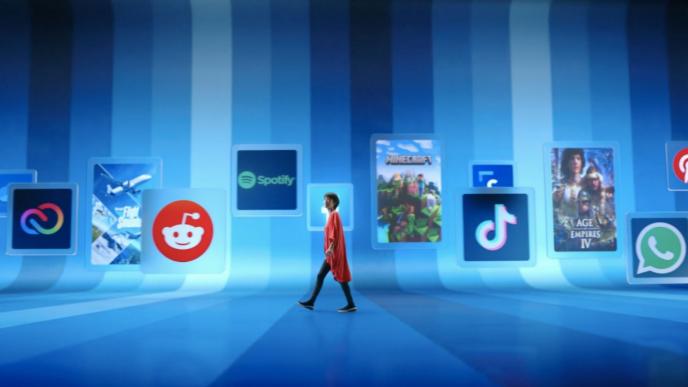 a person walking in the centre of a room covered in blue stripes of various tones. the wall behind them is covered in social media logos and video game posters