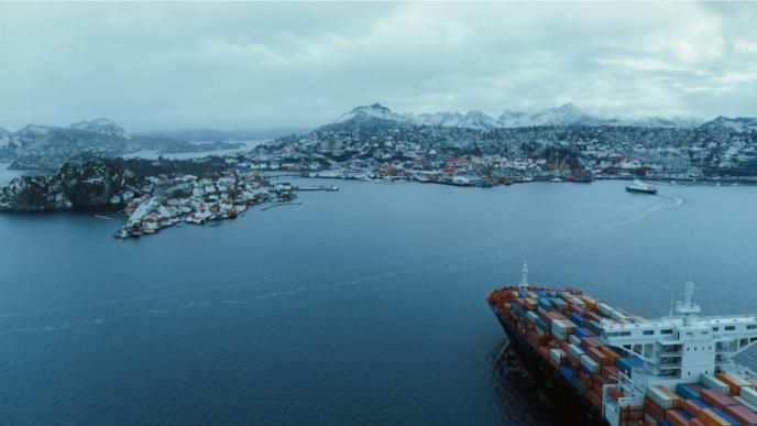 aerial view of a norway port. there is a container ship peaking out the right corner of the image