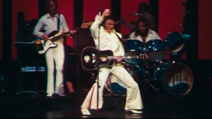 singer elvis presley singing and performing with a band