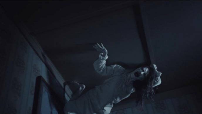 a possessed ghost screaming from the ceiling in a dark room