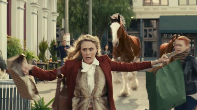 a concerned person running with their arms open. there is a horse in the background
