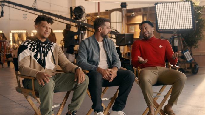 three people chatting and sitting in director chair in a film set