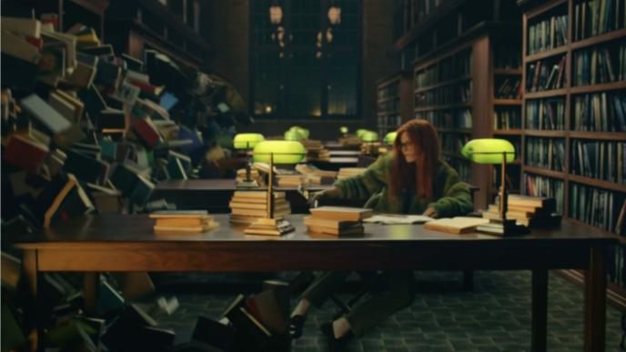 person sitting at a desk in a dimly lit library