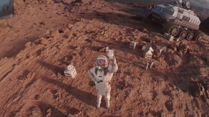 astronaut pointing upwards with their planet explorer in the background