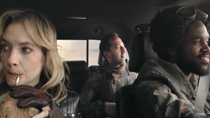 front shot of three people in a car looking out windows