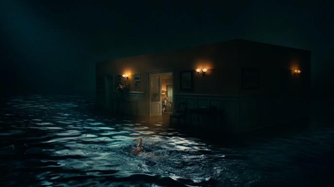 a person swimming by a dimly lit house that is floating on top of dark waters