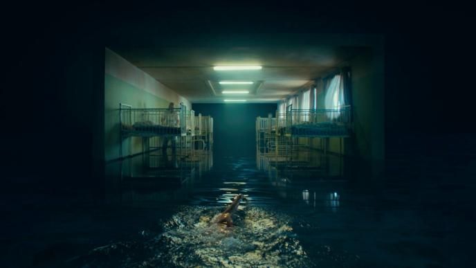a person swimming through a dimly lit orphanage in dark waters