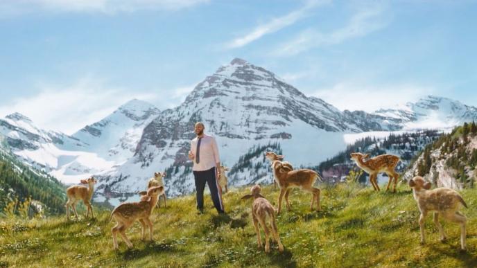 a person standing in mountainous terrain shouting along with cg animated deer that are also shouting