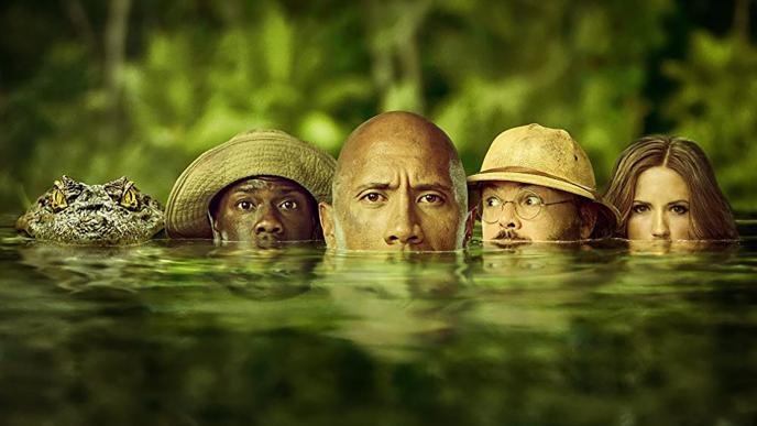 from left to right, an alligator and three jumanji characters submerged in water with their eyes and noses peaking through the water