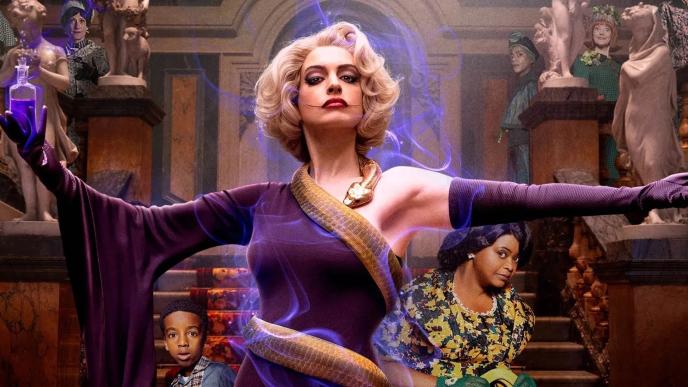 actress anne hathaway wearing a purple dress and a golden snake wrapped around her from the film 'the witches'