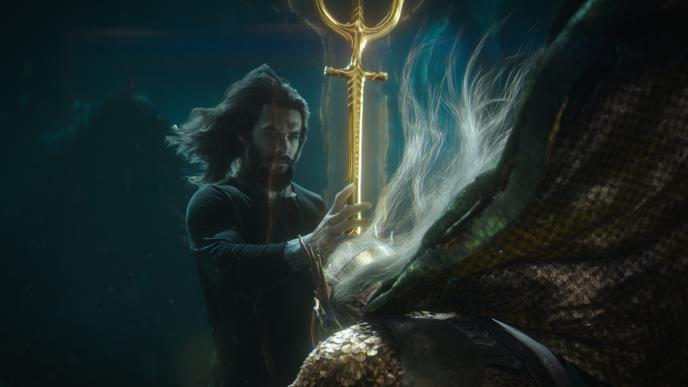 actor jason momoa as aquaman blessing someone with a trident underwater