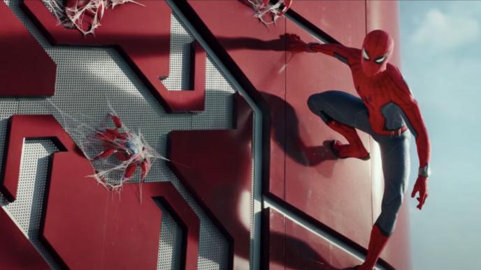spider-man looking down as he sticks to a wall 